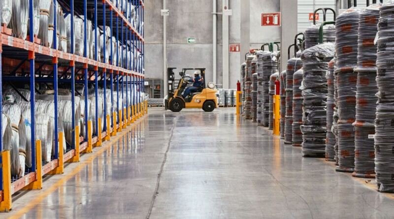 A forklift moving stacked goods through an industrial warehouse, illustrating artificial intelligence in business logistics.