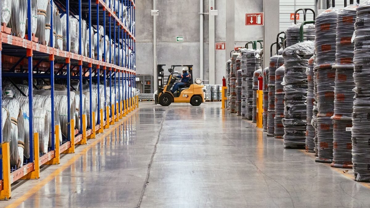 A forklift moving stacked goods through an industrial warehouse, illustrating artificial intelligence in business logistics.