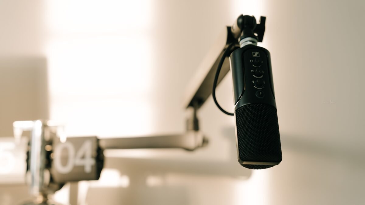 A condenser microphone on a boom arm in a studio, illustrating the best AI podcasts for listeners choosing a show.