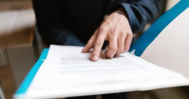 A finger pointing at printed text, illustrating a comparison of free AI tools and their tiers