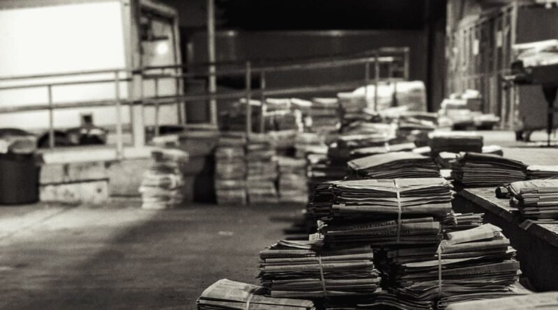 Stacks of folded newspapers in a warehouse, illustrating a reading stack for ai for news updates