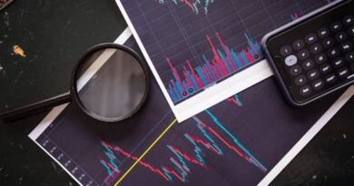 A magnifying glass and pocket calculator on printed stock market charts, illustrating how to read an ai startup funding round.