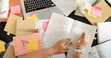 Overhead view of a desk with notebooks, handwritten study notes and an open laptop, illustrating how to learn artificial intelligence.