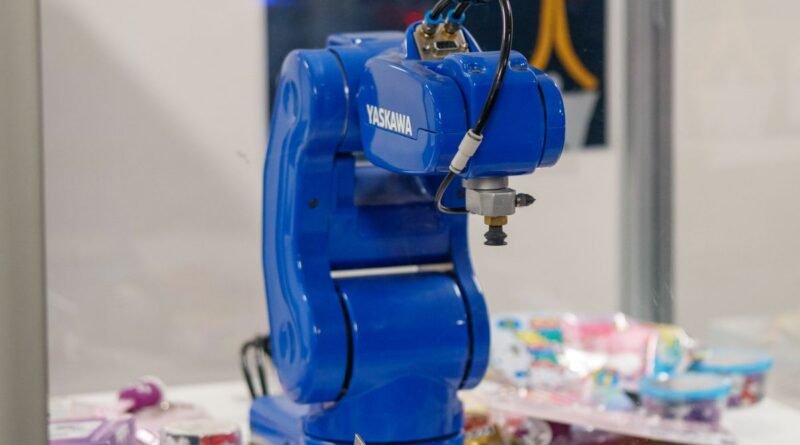 A blue industrial robot arm on display, the gap an AI robotics benchmark measures
