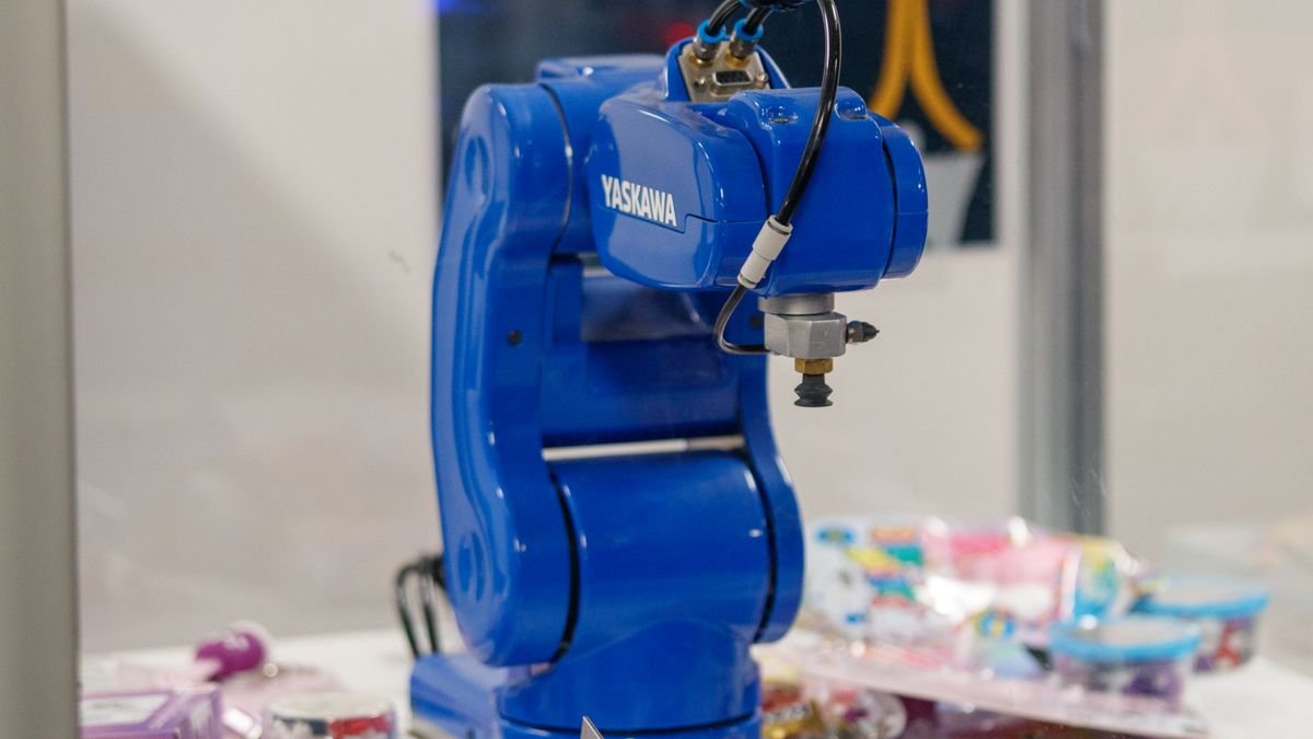 A blue industrial robot arm on display, the gap an AI robotics benchmark measures