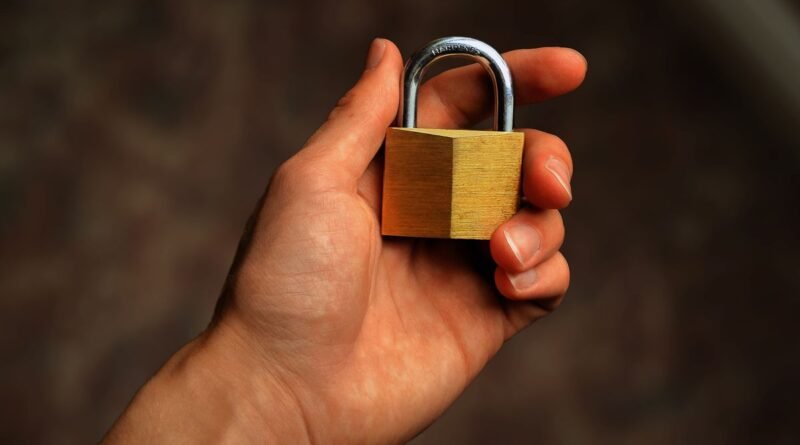 A hand holding a brass padlock, the deletion promised by the right to be forgotten in AI