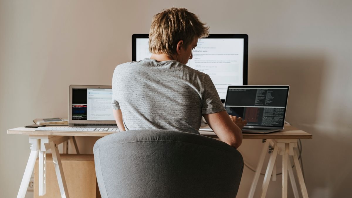 A developer coding at a home office, weighing AI agent frameworks against a hand-written loop
