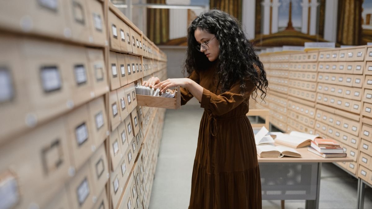 A woman searching a library card catalogue, the lookup step in retrieval augmented generation
