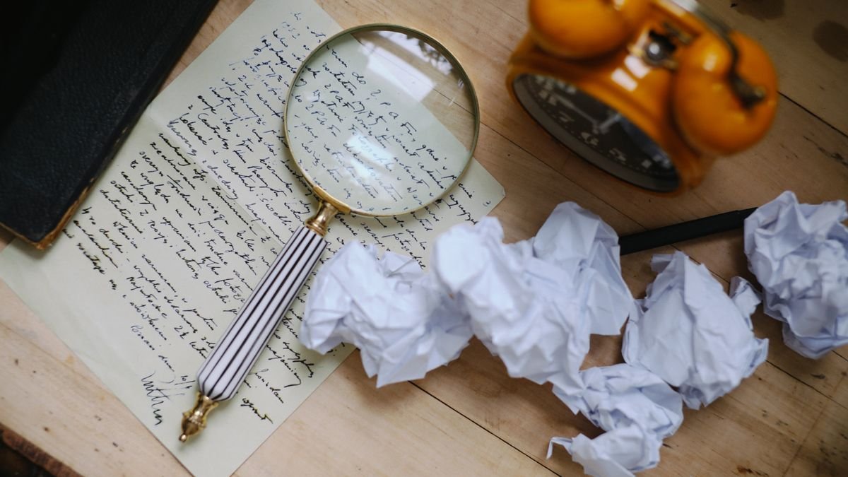 A magnifying glass over a handwritten letter, the scrutiny needed to detect AI generated text