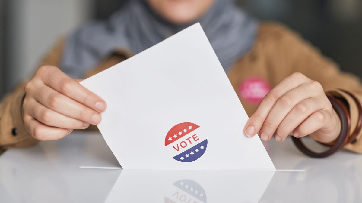 Hands holding a ballot paper, the vote that election deepfake laws protect