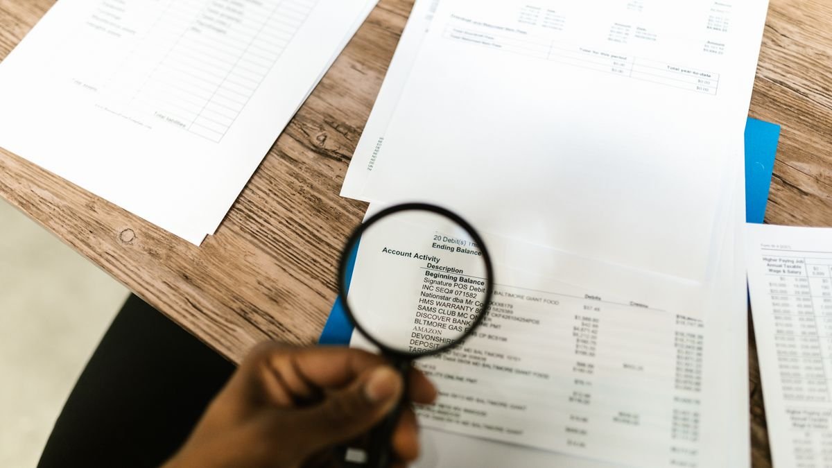 A magnifying glass held over documents, the review burden behind CodeRabbit funding