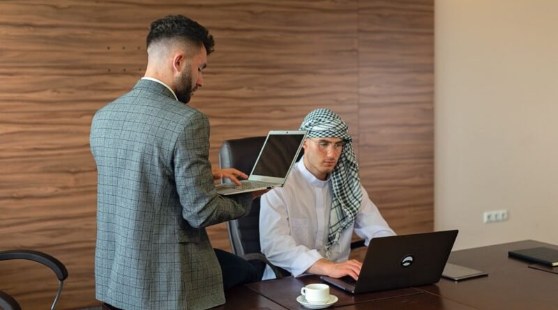 Two colleagues working at laptops in an office, the consulting work behind the IBM OpenAI partnership