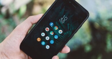 A hand holding a smartphone showing app icons, as Microsoft Copilot apps merge into one