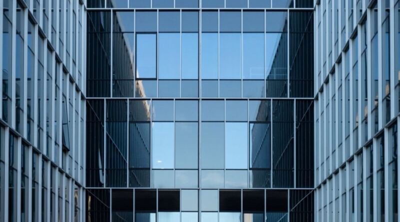 Two glass office towers reflecting a clear blue sky, illustrating enterprise artificial intelligence reaching production.