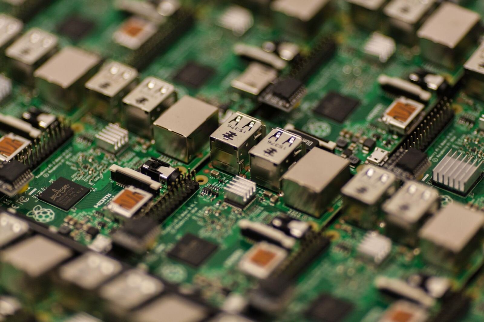 Rows of green single-board computers with silver USB and Ethernet ports, in shallow focus. Photo: Craig Dennis via Pexels