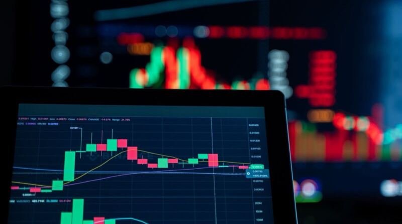 Laptop showing a candlestick trading chart, with blurred red and green market displays on a screen behind it