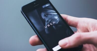 A hand holding a smartphone displaying the Uber app launch screen, the subject of the Dutch regulator's Uber GDPR fine