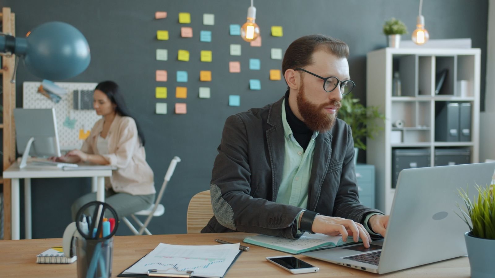 Young professionals working at desks in a modern open-plan office, illustrating artificial intelligence and business use by function