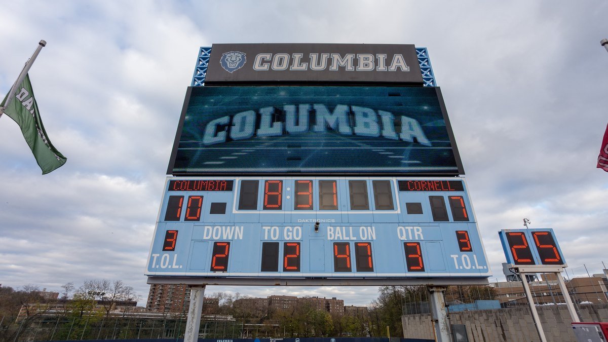 Stadium scoreboard showing a football score of 10 to 0 in orange digits, illustrating an AI model comparison where the same answers produce different scores