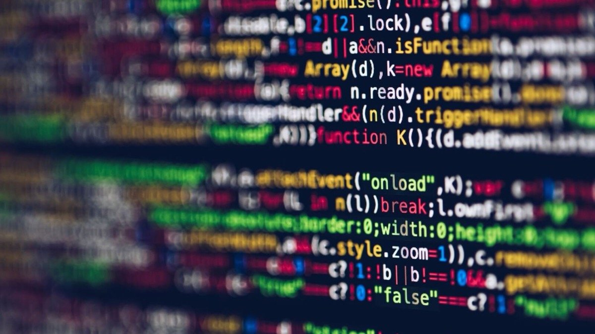 Blurred lines of colourful code on a dark monitor, illustrating the Ghost AI Core personal AI computer