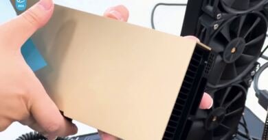 Hand holding a gold Nvidia H100 accelerator card beside an open PC, illustrating the Nvidia chip smuggling indictment