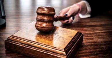 Wooden gavel resting on a sounding block as a hand reaches for it, illustrating the DeepSeek ban
