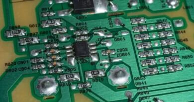 Close-up of a green circuit board with soldered components, illustrating OpenAI math papers released to GitHub