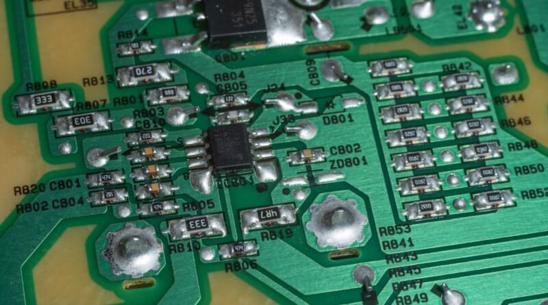 Close-up of a green circuit board with soldered components, illustrating OpenAI math papers released to GitHub