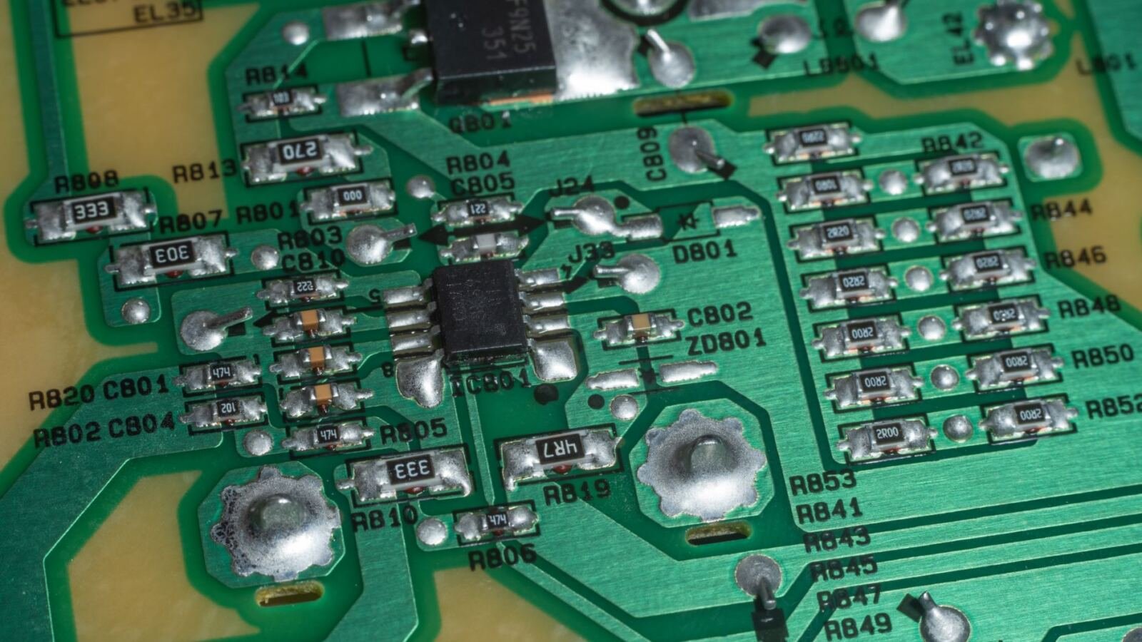 Close-up of a green circuit board with soldered components, illustrating OpenAI math papers released to GitHub