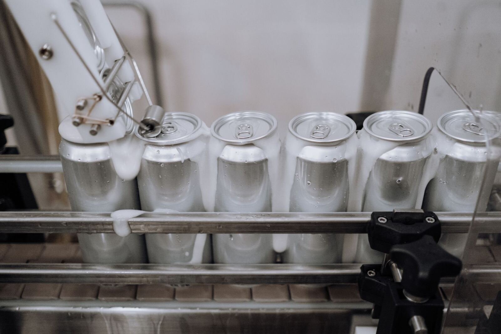 Aluminium drink cans on a factory conveyor line, illustrating the Nous Research $90M round